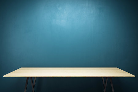 Wooden desk with blank surface on dark blue wall background, 3D Rendering, clean modern office interior, presentation or branding templateの写真素材