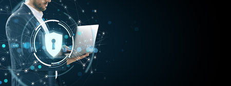 Business person using laptop with digital cybersecurity shield icon, futuristic light network...