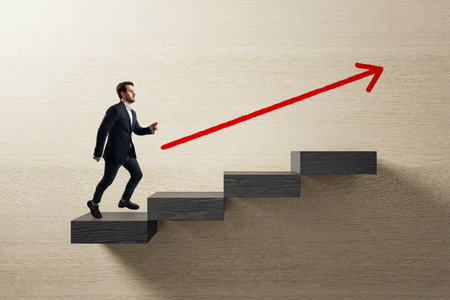 Confident businessman ascending stairs with red arrow on light wood background symbolizing career growth, ambition, and professional successの写真素材