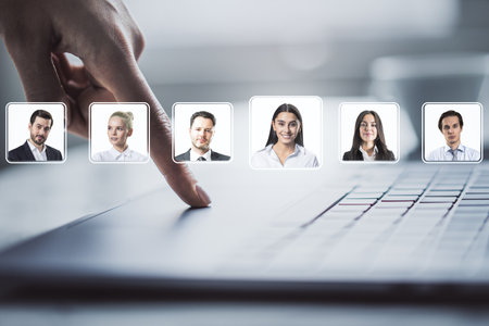 Business person choosing employee profile on digital interface over laptop, professional portraits, light background, concept of recruitmentの写真素材