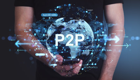 Person holding smartphone with P2P finance hologram, glowing technology elements and global map on abstract blue background, digital economy conceptの写真素材