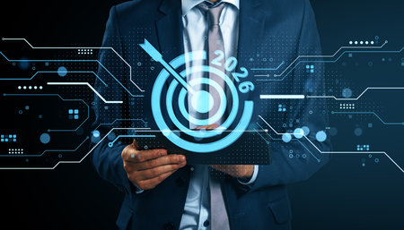 Businessman in suit using tablet with digital target and 2026 goal on abstract technology background with glowing light elements, future conceptの写真素材
