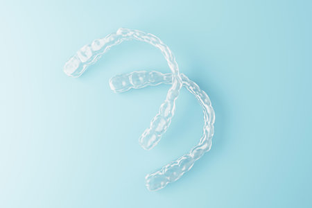 Clear dental aligners floating over a soft blue gradient background in modern minimal design style representing orthodontic medicine concept. 3D Renderingの写真素材