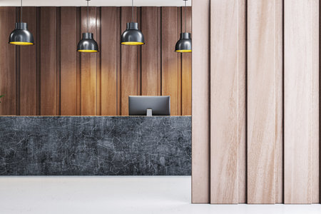 Black marble reception desk in modern office lobby with warm wooden wall panels, pendant lights, and clean minimal workspace interior. 3D Renderingの写真素材