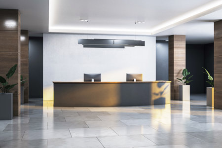 Stylish office reception desk with two monitors, modern light, and plants in a corporate hallway interior with warm lighting. 3D Renderingの写真素材