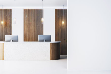 Contemporary office reception with marble counter, pendant lights, wood panel backdrop, and large blank wall for logo or poster mockup. 3D Renderingの写真素材