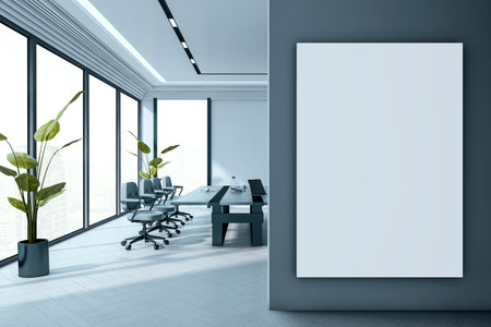 Blank vertical canvas poster on dark wall in modern office boardroom interior with clean desk, chairs, plants, and large windows. 3D Renderingの写真素材