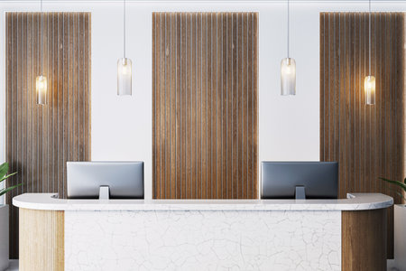 Stylish reception desk with marble texture and dual monitors, wood panel wall background, hanging lights, modern office interior. 3D Renderingの写真素材