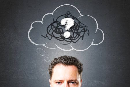 Portrait of a man with a scribble cloud and question mark above his head, chalkboard style on dark background, symbolizing confusion and inquiryの写真素材