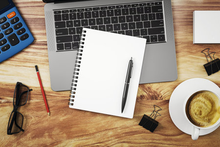 Blank notepad with pen on wooden desk beside laptop, coffee cup, and office items in top view layout, clean workspace concept, 3D Renderingの写真素材
