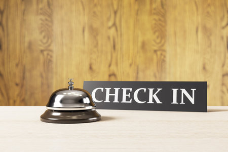 Silver service bell and check-in sign on light wood desk, soft blur wooden background, hospitality reception interior concept, 3D Renderingの写真素材