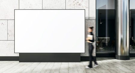 Large bill blankboard on exterior stone wall of building with blurred person walking, clean background, concept for outdoor branding or posterの写真素材