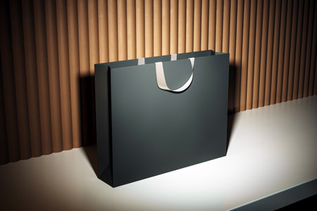 Minimalist black shopping bag with white handle on light floor, wooden wall background, clean retail branding concept, mockup for promotion. 3D Renderingの写真素材