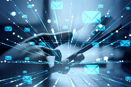 Hands using tablet with glowing email icons and light lines overlay on abstract blue background, concept of virtual communication and messagingの写真素材