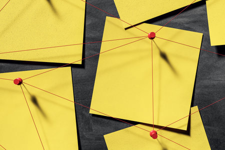 Yellow square stickers with red pins and strings on dark wall background, in 3D Rendering style, representing detective investigation conceptの写真素材