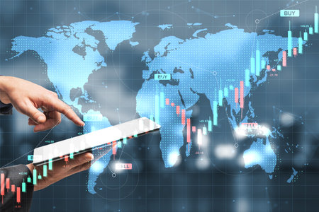 Hands using a tablet with digital forex charts and graphs over a glowing world map background, concept of global financial trading and economyの写真素材