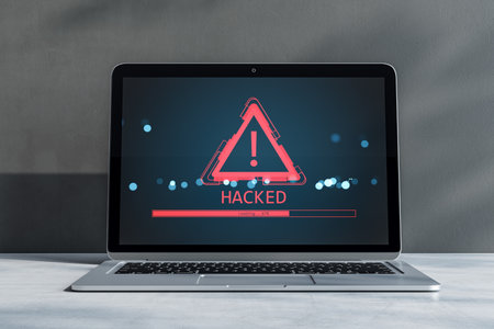 Laptop screen with red exclamation warning icon and hacked alert text, digital light effects, on gray background. Concept of cyber intrusion. 3D Renderingの写真素材