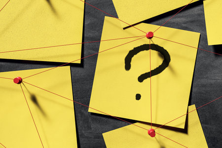 Yellow sticky notes connected with red strings and pins on dark wall background, symbolizing detective investigation, problem solving, and curiosity. 3D Renderingの写真素材