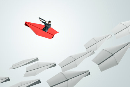 Businessman on red paper plane with telescope leading white planes, light background, abstract concept of leadership, future vision and directionの写真素材