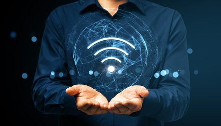 Businessman showing glowing wireless symbol with global digital network on dark background, symbolizing modern technology connection conceptの写真素材