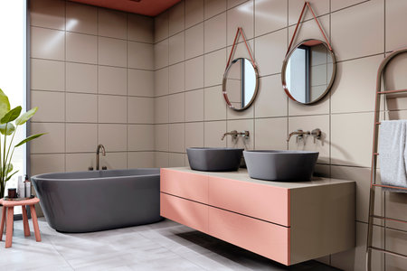 Contemporary bathroom with black bathtub, dual sinks on pink vanity, round mirrors, beige tiled...