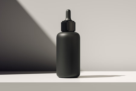 Black dropper bottle mockup on white surface, realistic 3D Rendering, with light gradient background, concept for modern cosmetic brandingの写真素材