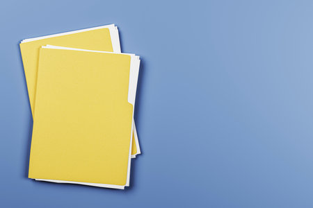 Yellow file folders with white documents on a light blue desk background, top view layout for business, office, or report presentation concept. 3D Renderingの写真素材