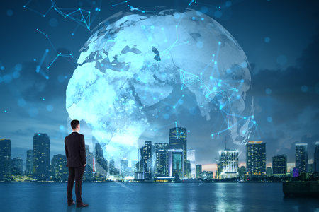 Businessman watching glowing world map with digital connections, over cityscape at night, symbolizing global internet network and technologyの写真素材