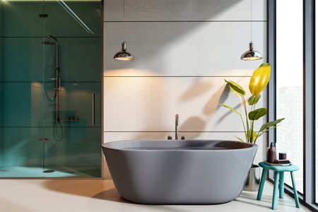 Stylish bathroom with gray bathtub, glass shower, pendant lights, potted plant, and city view window...