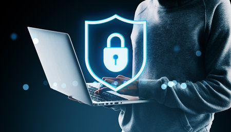 Person using laptop with glowing padlock shield icon, digital style, on dark background. Concept of...