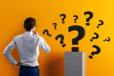 Businessman from rear view thinking with floating question marks around, realistic style, orange background, concept of curiosity and problem solvingの写真素材