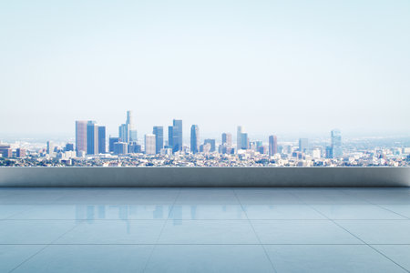 Rooftop with clean tiled floor overlooking a modern city skyline in daylight on a clear sky background. Concept of empty space and design mockupの写真素材