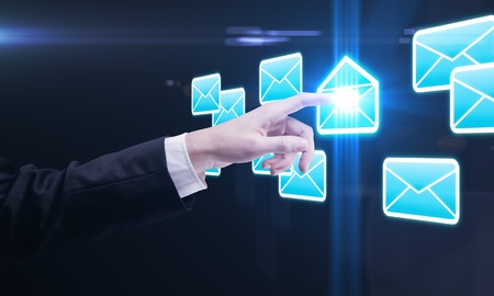 Young business man pressing a envelope touchscreen buttonの写真素材