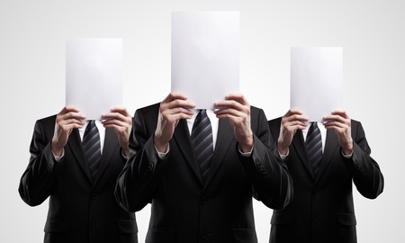group of business people in dark suits holding a blank signsの写真素材