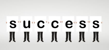 seven man holding a white board with word success