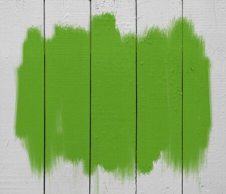green paint brush strokes on white wooden plankの写真素材