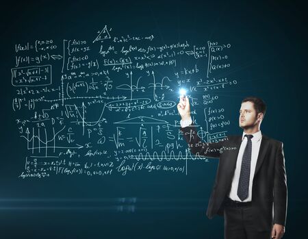 man drawing mathematical formulas on a blue boardの写真素材