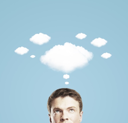 businessman and a cloud of thoughts on a blue backgroundの写真素材