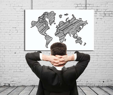 businessman sitting and map on wallの写真素材