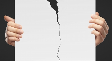 hands holding a torn  placardの写真素材