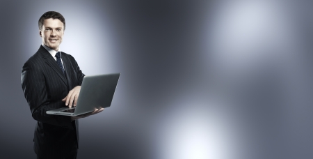 businessman standing with laptop in handの写真素材