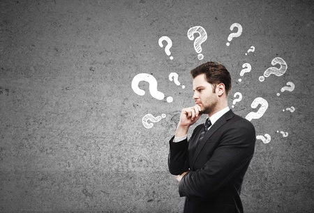 businessman having questions and concrete wallの写真素材