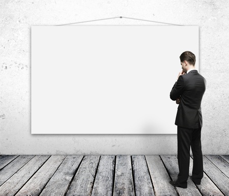 man looking empty poster on wallの写真素材