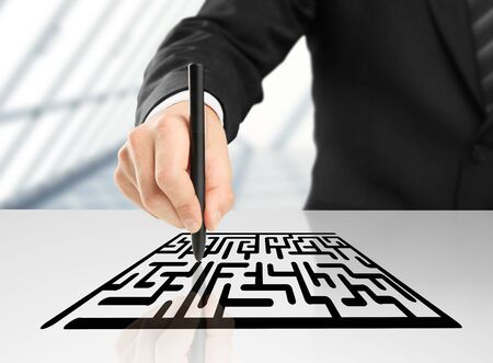 businessman drawing labyrinth on a white backgroundの写真素材
