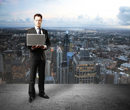 businessman with laptop on city backgroundの写真素材
