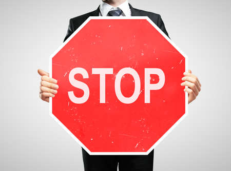 businessman holding a stop signの写真素材