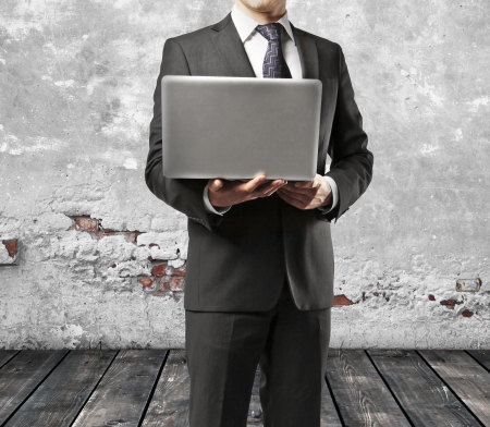businessman with laptop in grunge roomの写真素材