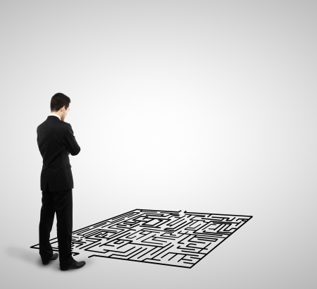 businessman looking at labyrinth on a white backgroundの写真素材