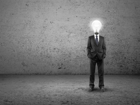 businessman with lamp-head on a concrete roomの写真素材