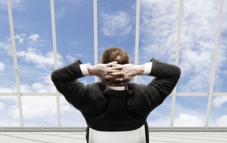 businessman sitting in a chair looking out the windowの写真素材